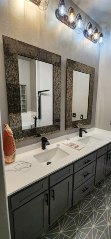Double vanity with mosaic mirror frames and pendant lights