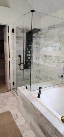 Shower and tub combo with marble tile and hex floor