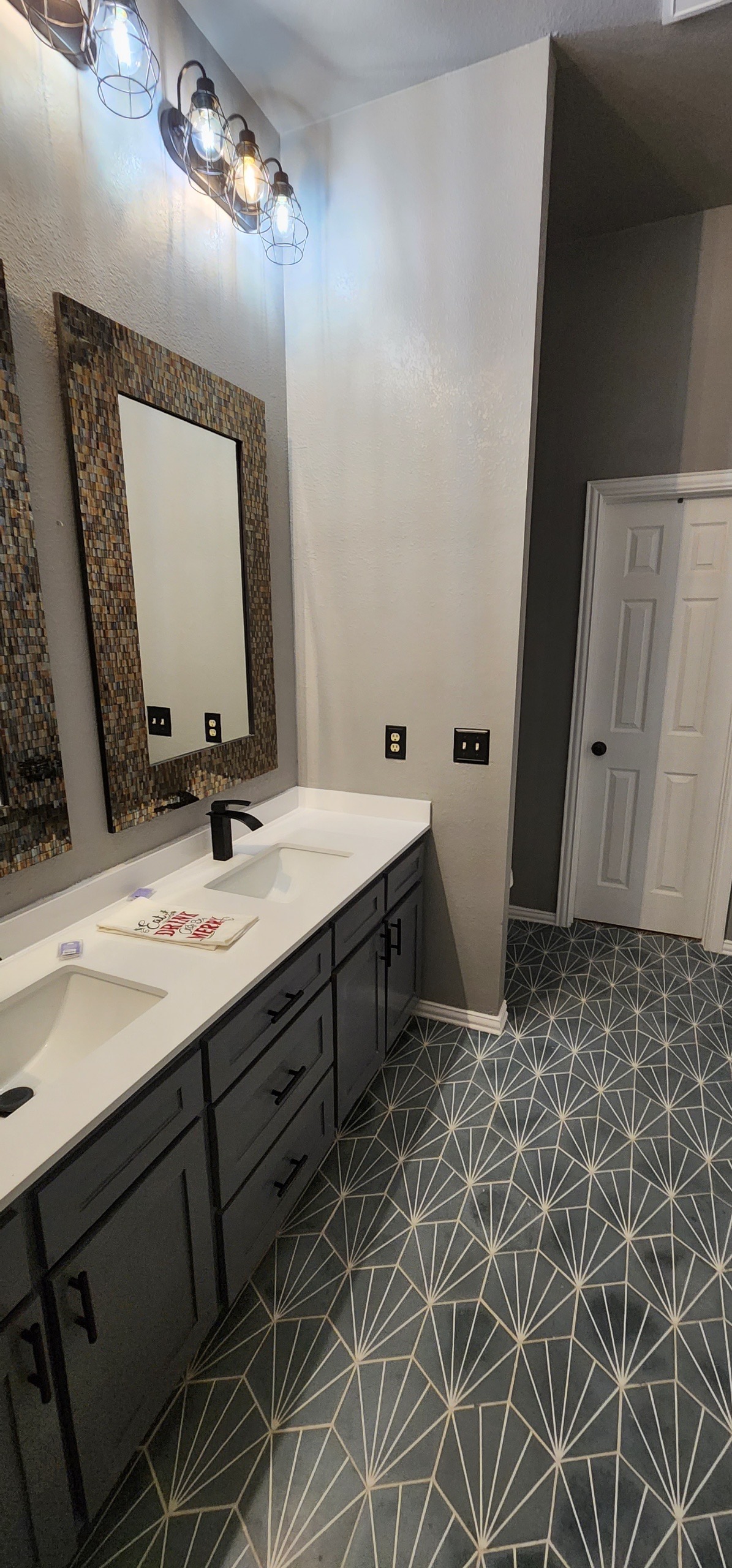 Tub area with geometric tile floor and glass block window