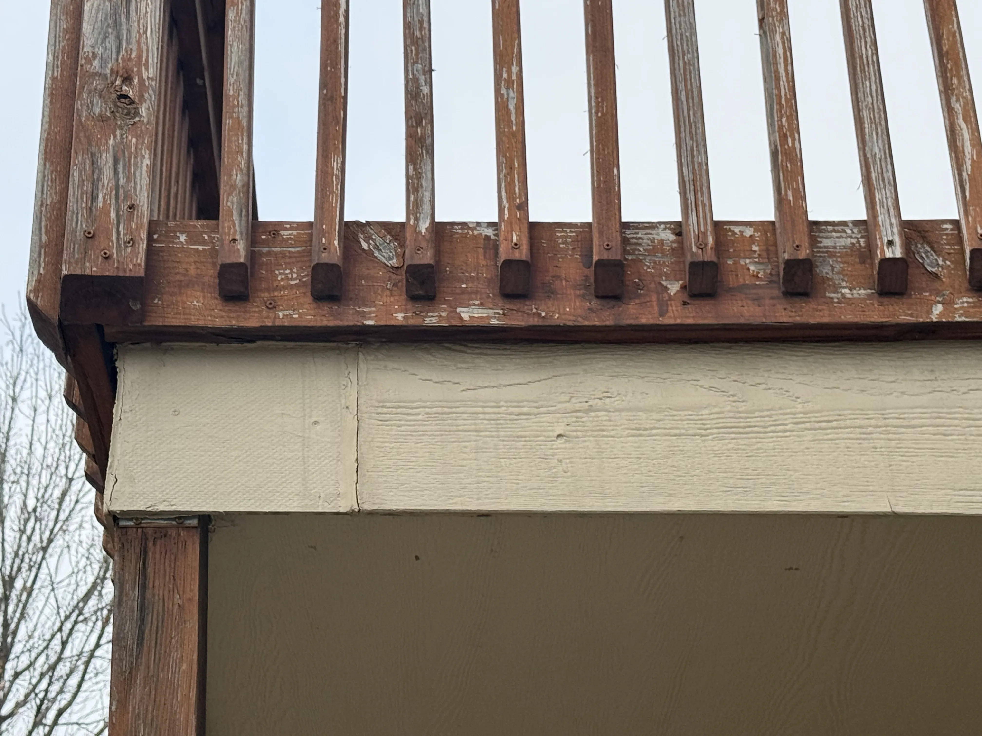 Elevated deck with weathered wood railing before replacement